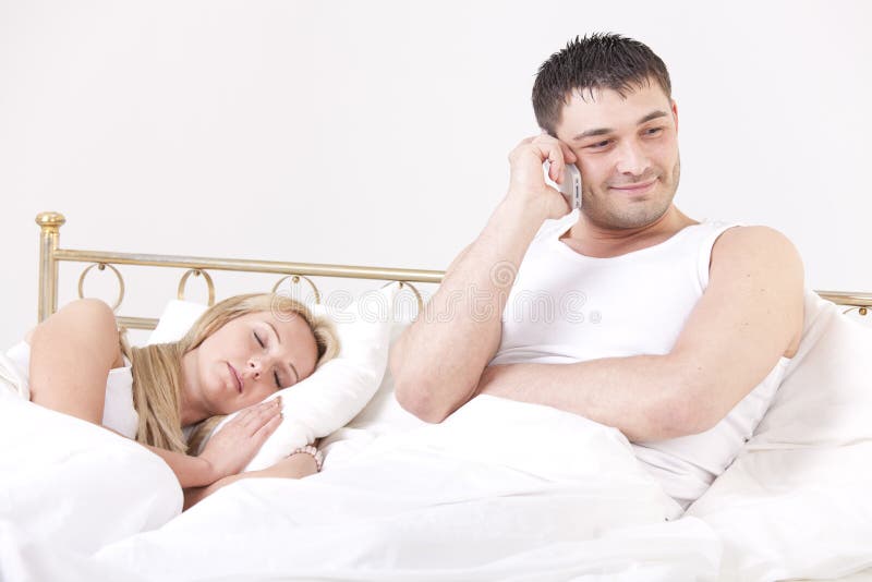 Couple in bed - men cheating while a women sleeping. Couple in bed - men cheating while a women sleeping