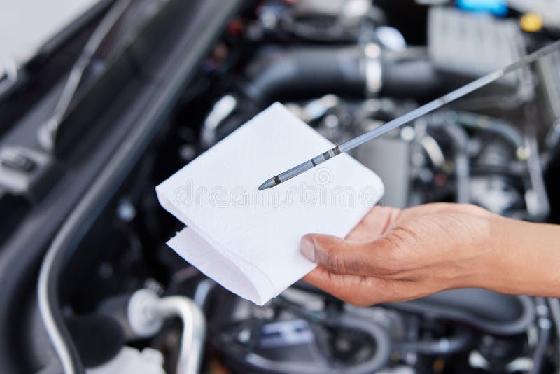 CloseUp of Man Checking Car Engine Oil Level on Dipstick Stock Photo