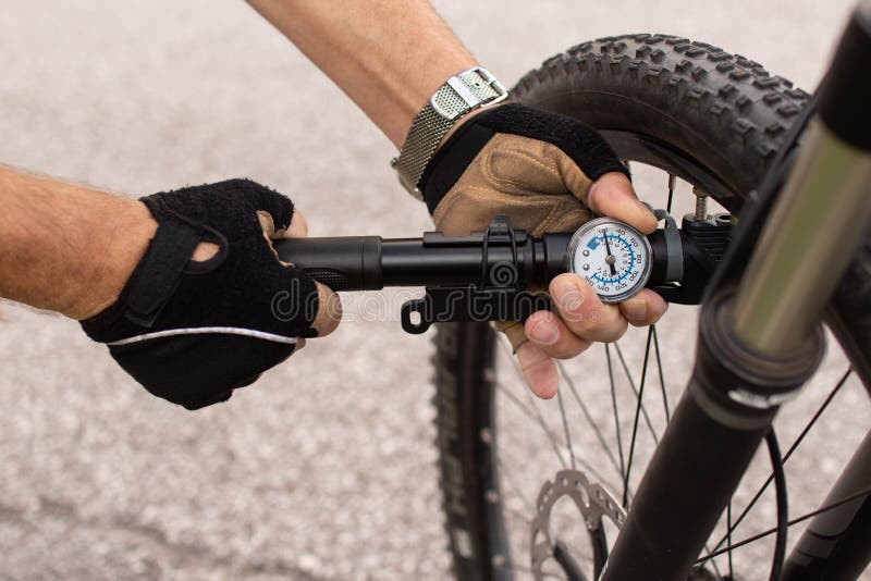 Man Checking Tire Pressure of E Bike, Inflating Air with Hand Pump