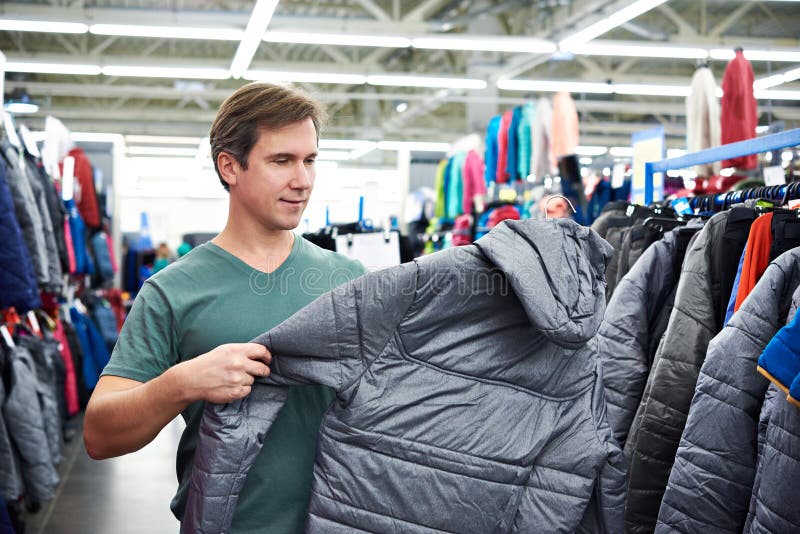 Man chooses winter jacket in store