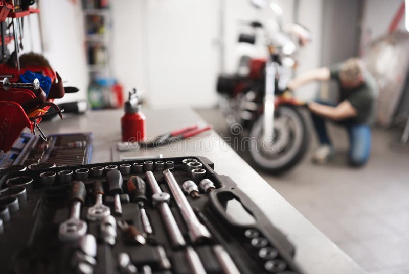 Man With Classic Motorcycle In Garage royalty free stock image