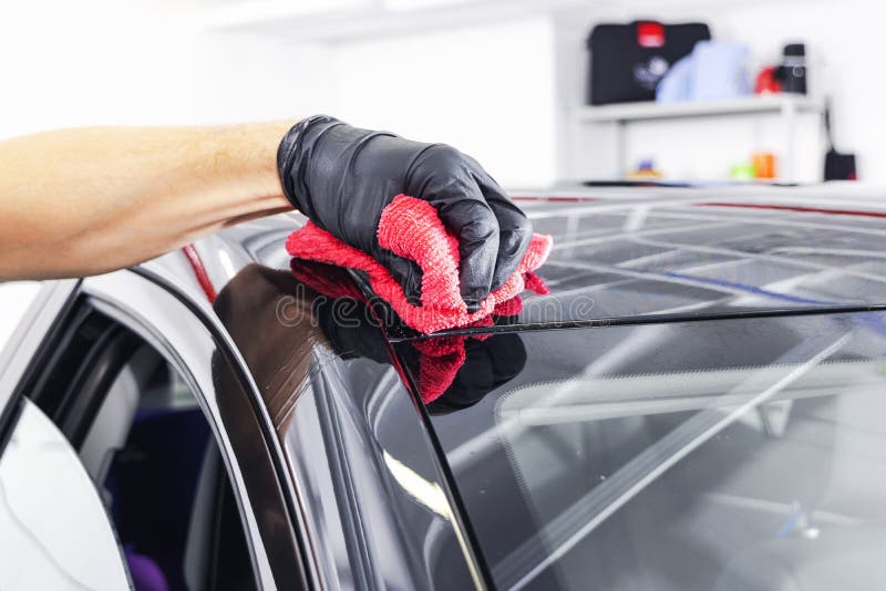A man cleaning car with microfiber cloth. Car detailing or valeting concept. Selective focus. Car detailing. Cleaning with sponge. Worker cleaning. Car wash concept solution to clean