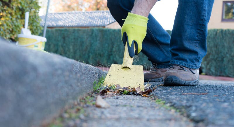 Man is cleaning the gutter stock image