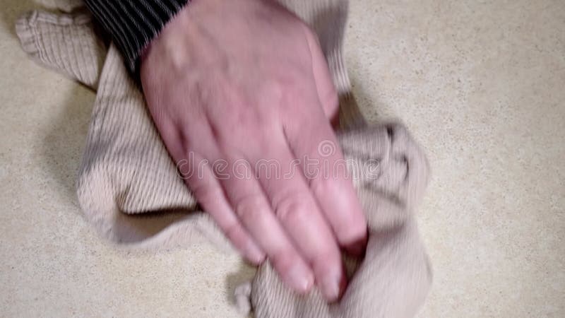 The man is cleaning the house. Hand wipes dirt off the table with a rag. Top view