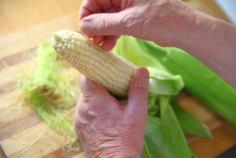 Man Cleaning Silks Off Fresh Corn Stock Photo Image of holding, fresh