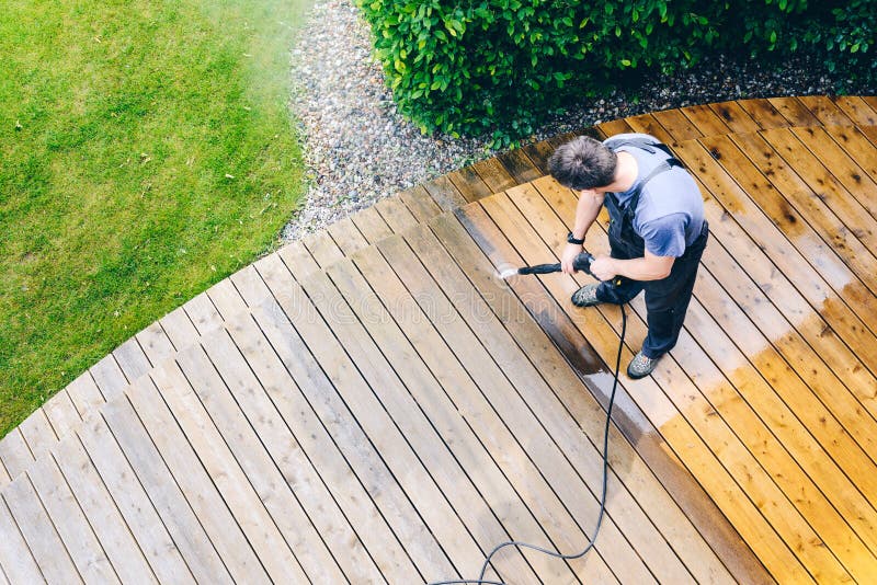 man cleaning terrace with a power washer - high water pressure c