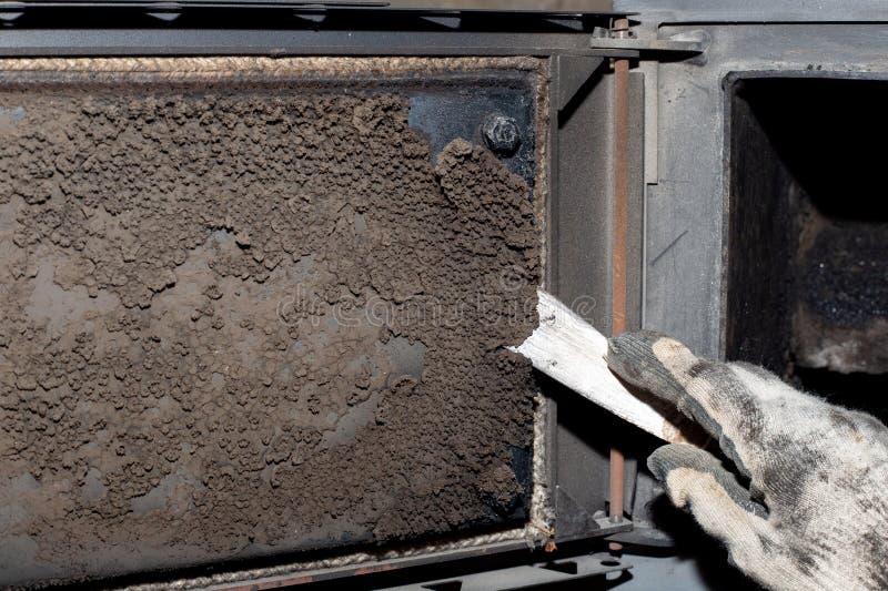 A Man Cleans a Solid Fuel Boiler from Soot and Soot. Maintenance of