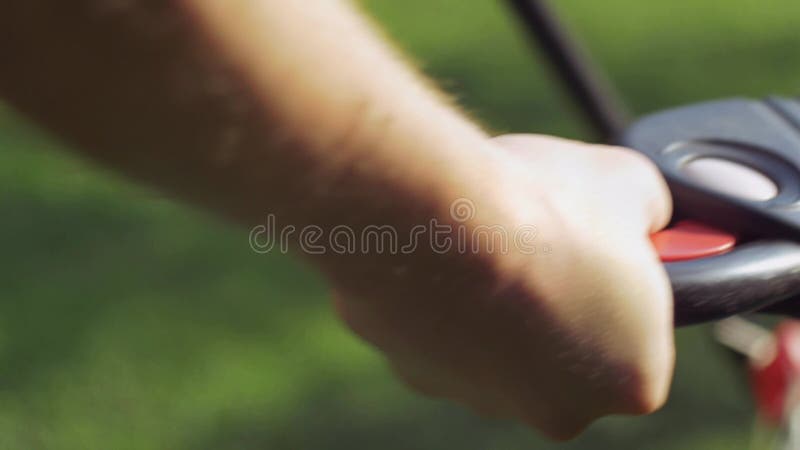 A man clicks on a button from starts lawn mower stock video footage