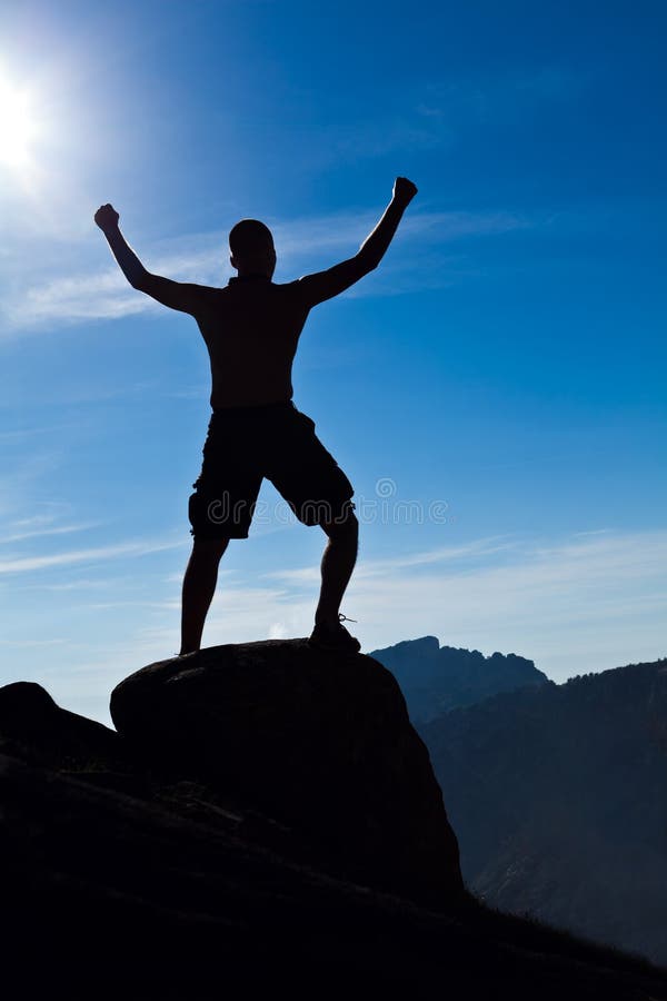 Man climbing in mountains arms outstretched