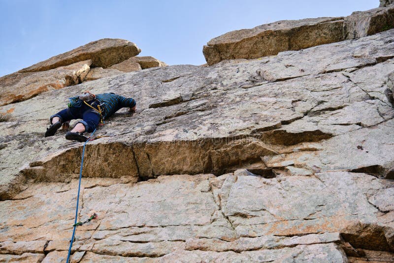Man Climbing a Rock Wall with Climbing Equipment. Stock Photo Image