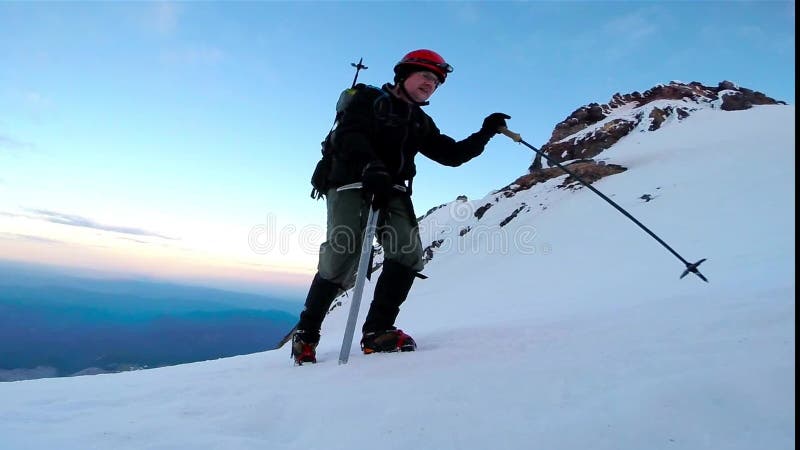 Man Climbing Up Snowy Mountain Ice Axe and Crampons stock footage