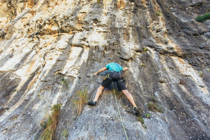 Man Climbs on the Rock Wall. Climbing Gear. Climbing Equipment Stock