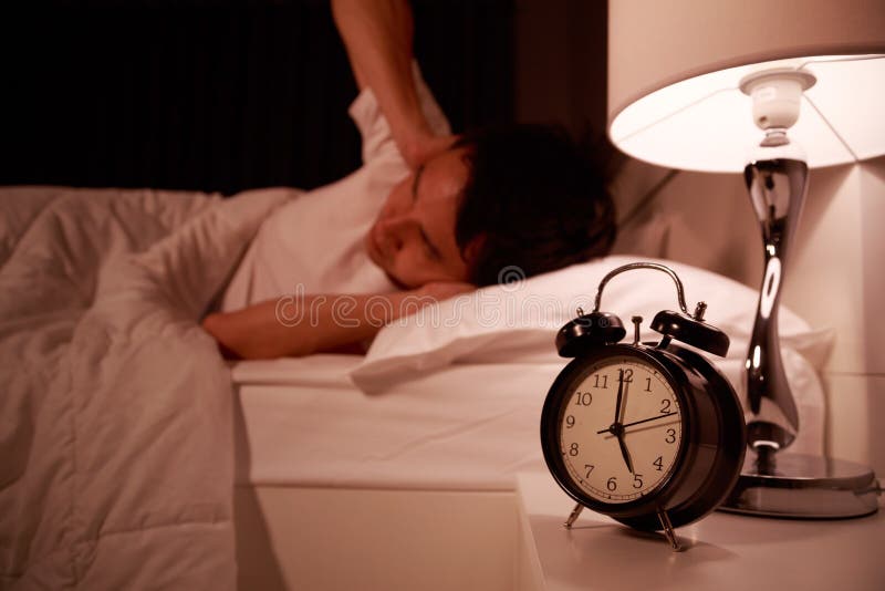 Man close his ears by hand from noise of alarm clock on bed royalty free stock images Man close his ears by hand from noise of alarm clock on bed royalty free stock images