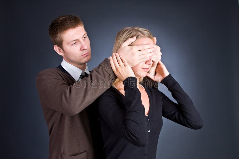 The man closes hands behind an eye of the girl.