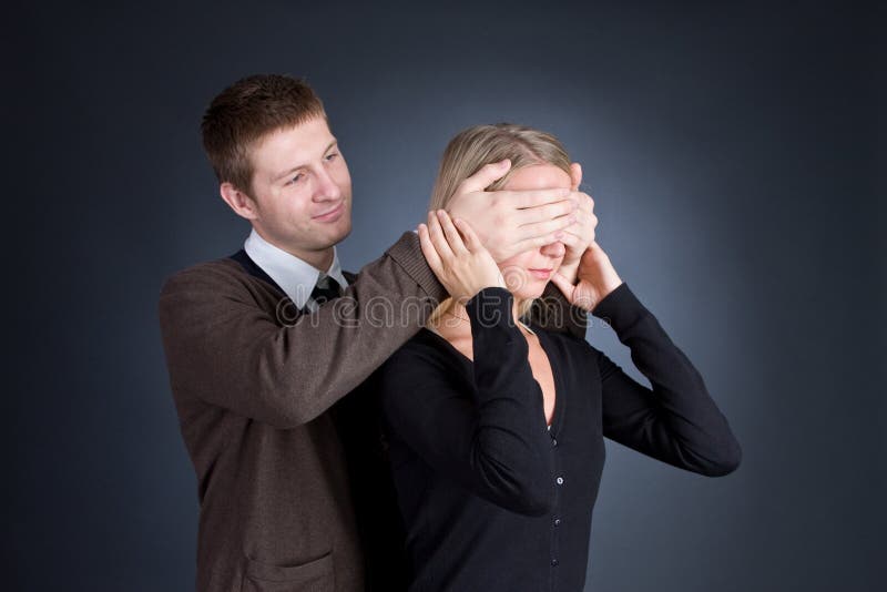 The man closes hands behind an eye of the girl.