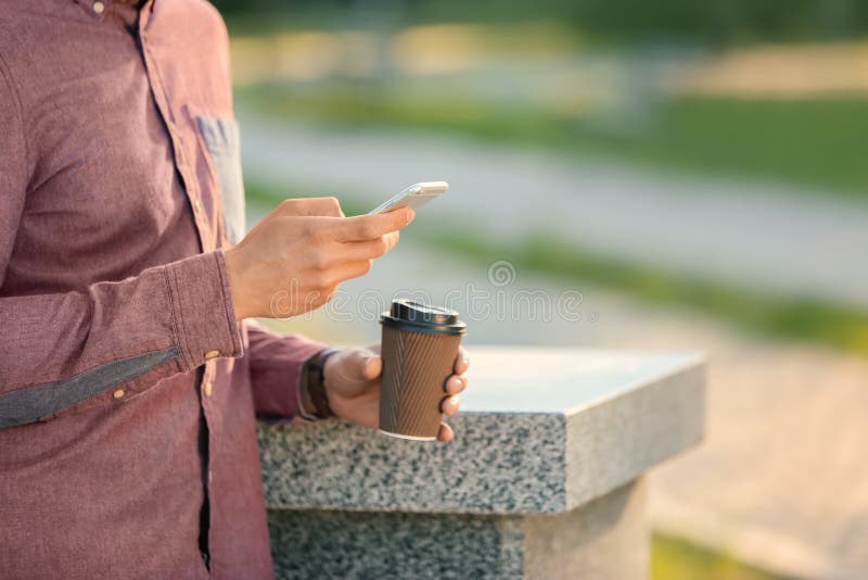 Man with Coffee and Mobile Phone in Park, Closeup Stock Image Image