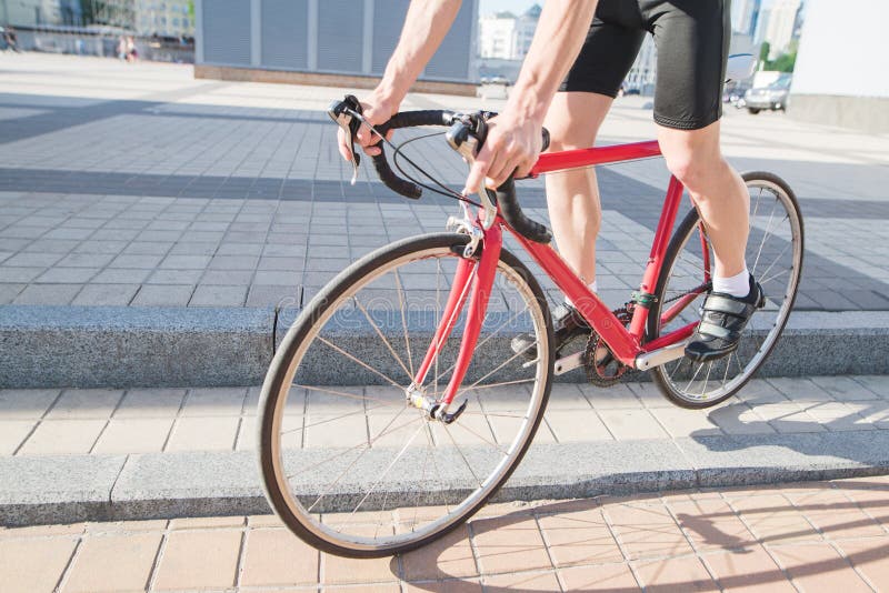 Man comes down from the curtain on a city red road bike. A cyclist cycling around the city stock photography Man comes down from the curtain on a city red road bike. A cyclist cycling around the city stock photography