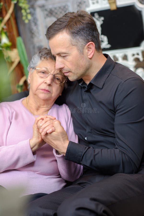 Man comforting elderly woman royalty free stock images