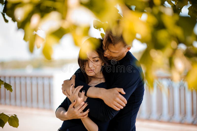 Man in love comforting his smiling women outdoor. Man in love comforting his smiling women outdoor