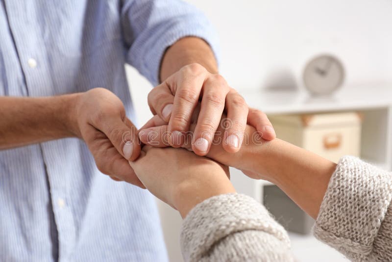 Man comforting woman on blurred background, closeup of hands. Help and support concept