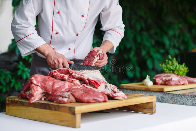 A Man Cook Cuts Meat with a Knife in a Restaurant Stock Image Image