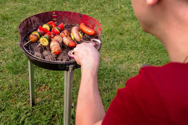 Man Cooking at Grill with Various Delicious Barbecue Outdoor, Selective Focus Stock Photo