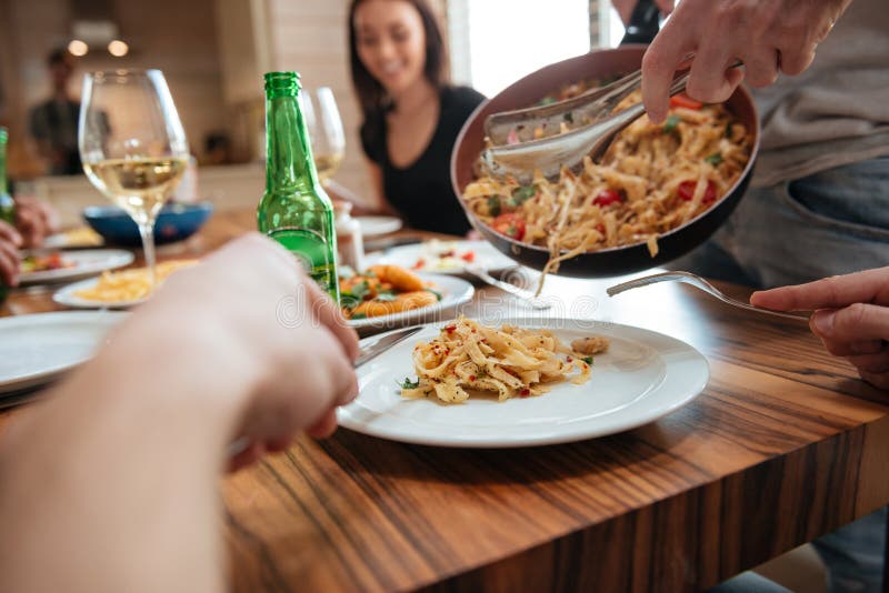 Man Cooking Pasta and Having Dinner with Friends at Table Stock Photo ...