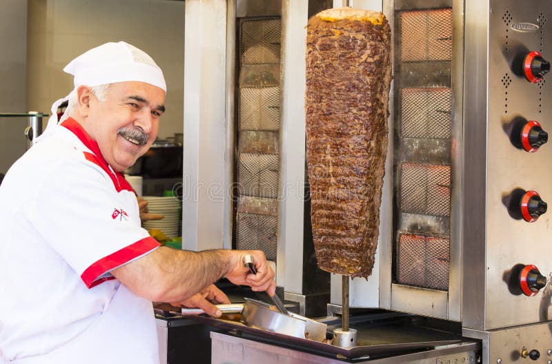 Man cooks Turkish meat kebab at a street cafe