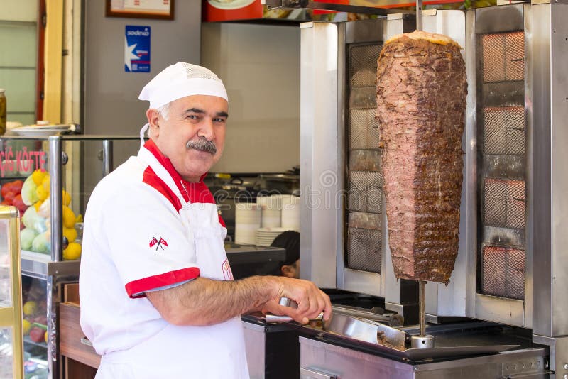 Man cooks Turkish meat kebab at a street cafe