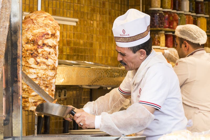 Man cooks Turkish meat kebab at a street cafe