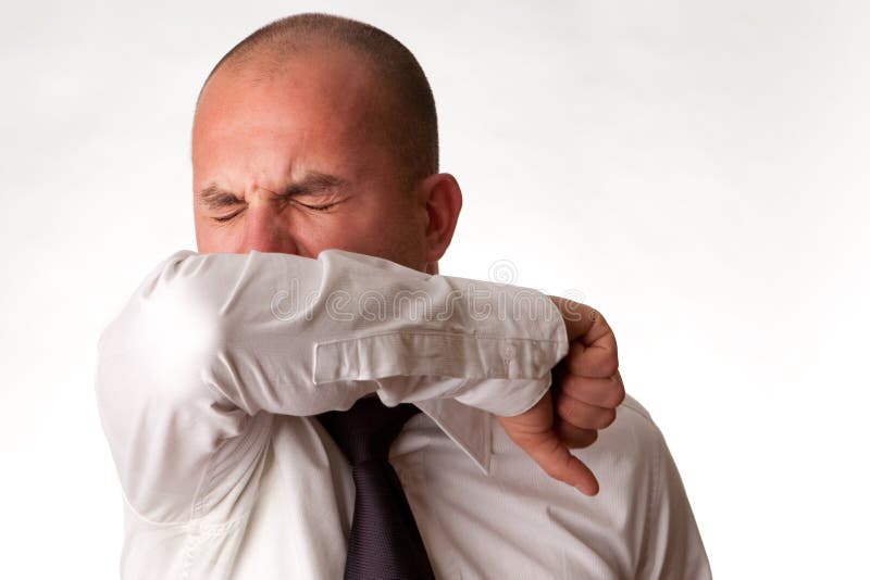 Un uomo tosse / starnuti nel gomito / braccio per non diffondere i germi.
