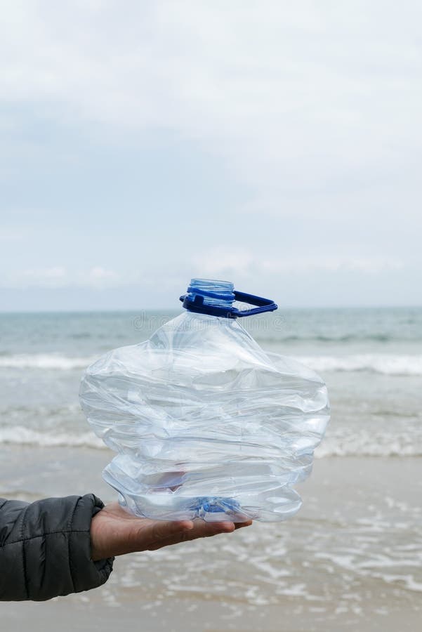 Man with a Crushed Plastic Bottle on the Beach Stock Photo - Image of ...