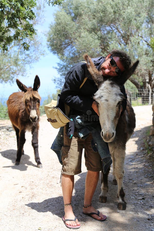 A Man Cuddles the Donkey. Menorca, Spain. 2016 Editorial Photography