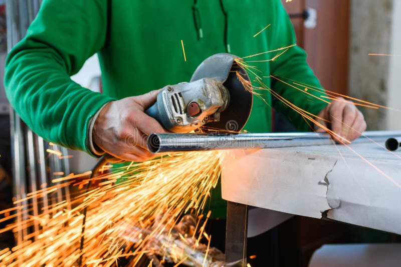 A Man Cuts Off Part of a Pipe with a Grinder Stock Image Image of factory, equipment 204640469