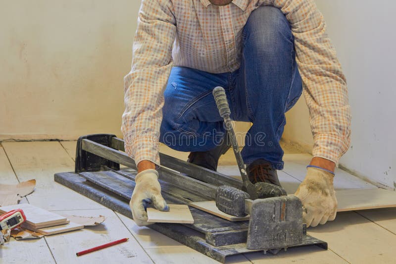 A Man is Cutting a Ceramic Tile with a Tile Cutter,the Work of a
