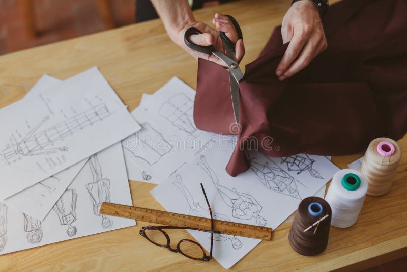 Man cutting fabric with scissors on table royalty free stock images Man cutting fabric with scissors on table royalty free stock images