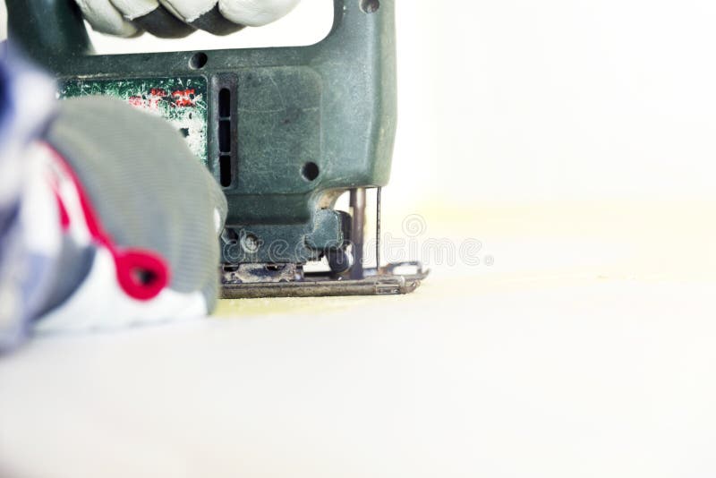 Man Cutting Kitchen Countertop Using Electric Jigsaw. Home Improvement, Renovation Concept Stock