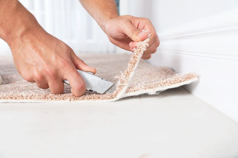 Man Cutting New Carpet Flooring Indoors, Closeup. Stock Photo Image