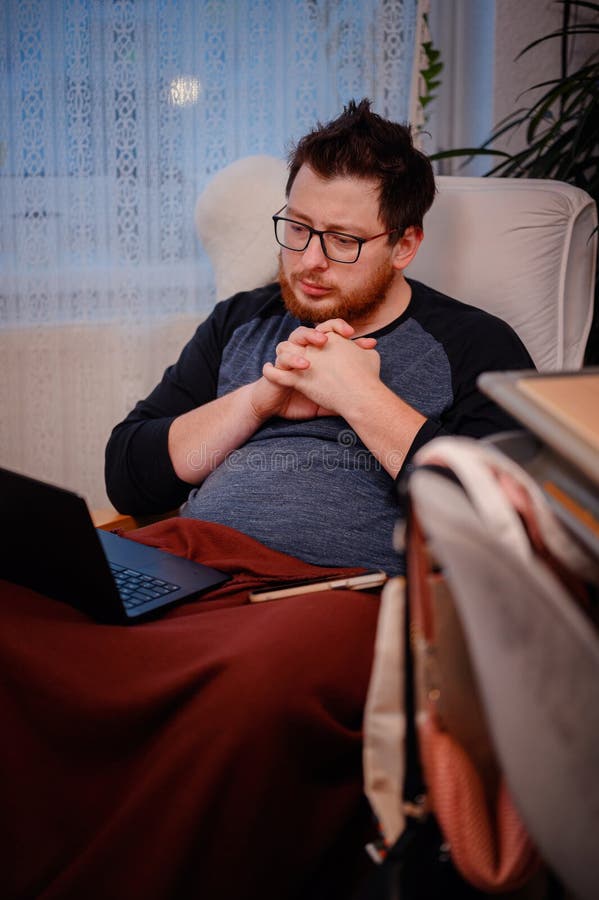 Man Dein Think mentre utilizza il notebook a casa fotografia stock