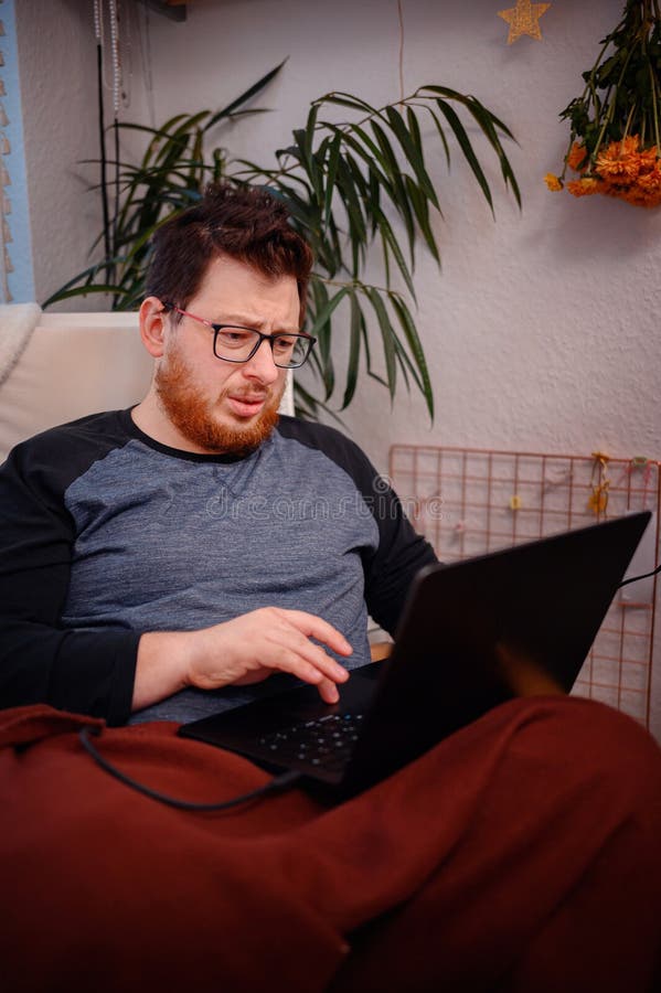Man Dein Think mentre utilizza il notebook a casa immagini stock