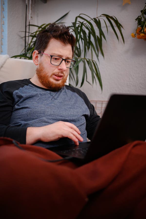 Man Dein Think mentre utilizza il notebook a casa fotografia stock