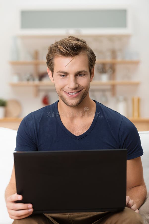 Man with a delighted smile using a laptop