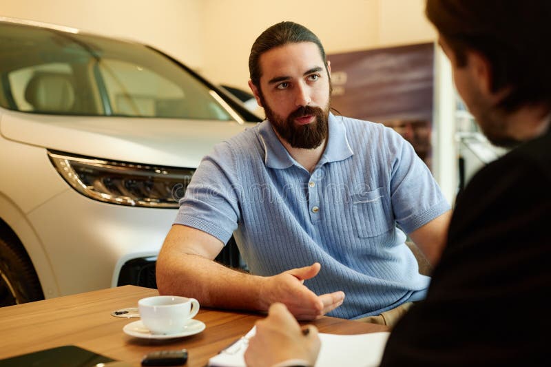 Man at Desk Discussing Contract with Auto Dealer at Dealership Center stock photography