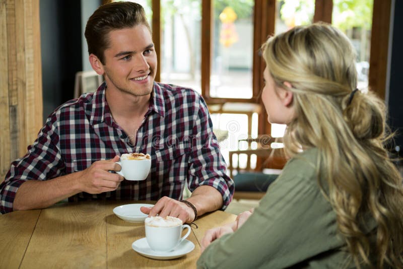 Man die koffie hebben terwijl het spreken met vrouw in koffie stock fotografie Man die koffie hebben terwijl het spreken met vrouw in koffie stock fotografie