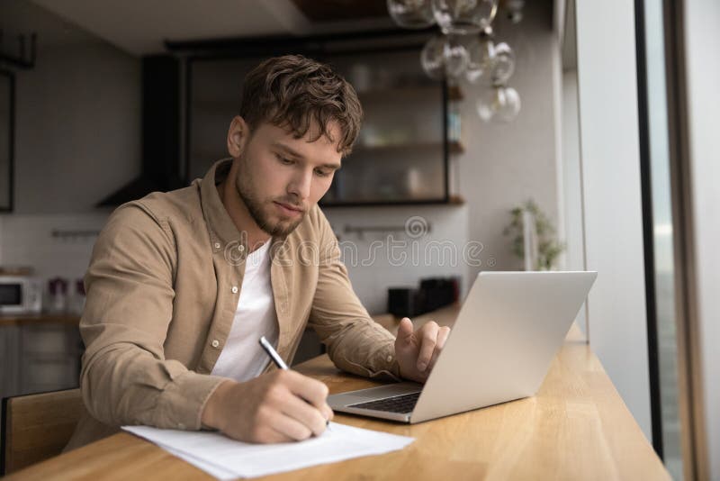 Man die thuis werkt door gegevens op te schrijven vanaf het laptopscherm