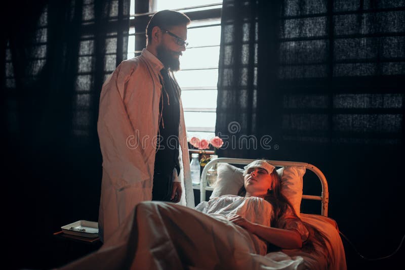 Man die zich tegen zieke vrouw in het ziekenhuisbed bevinden royalty-vrije stock fotografie Man die zich tegen zieke vrouw in het ziekenhuisbed bevinden royalty-vrije stock fotografie