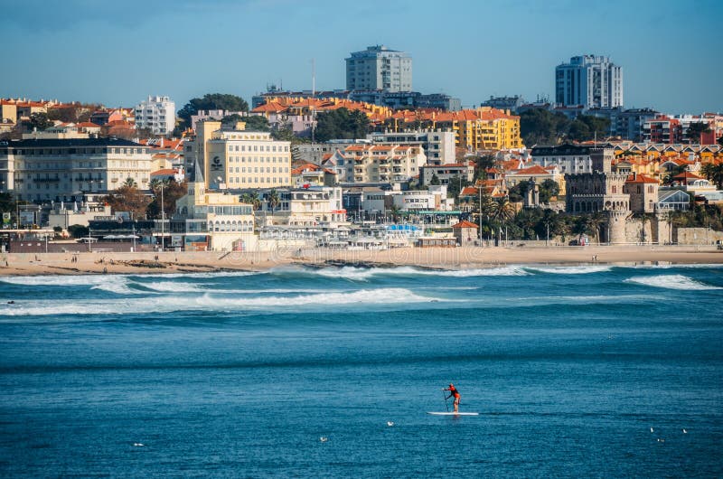 Estoril, Portugal - Nov 30, 2018: Man does stand up paddle overlooking the coast of Estoril near Lisbon, Portugal - with copy space