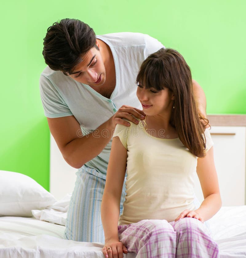 Man Doing Massage To His Wife in Bedroom Stock Photo