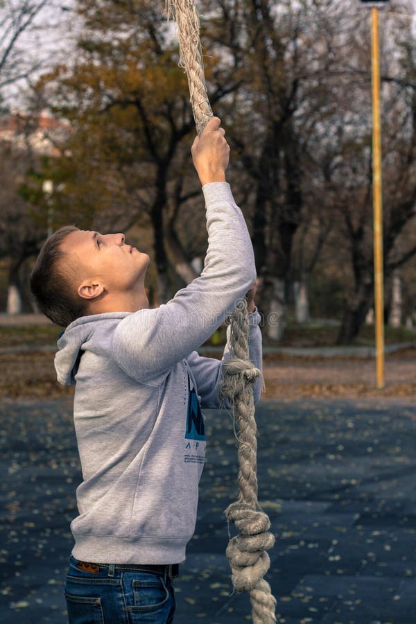 Man doing rope climbing fitness exercise. stock images