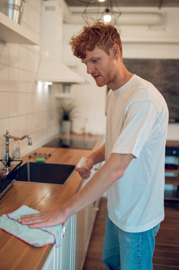 Man Doing Some Housework and Cleaning Some Surfaces Stock Photo Image